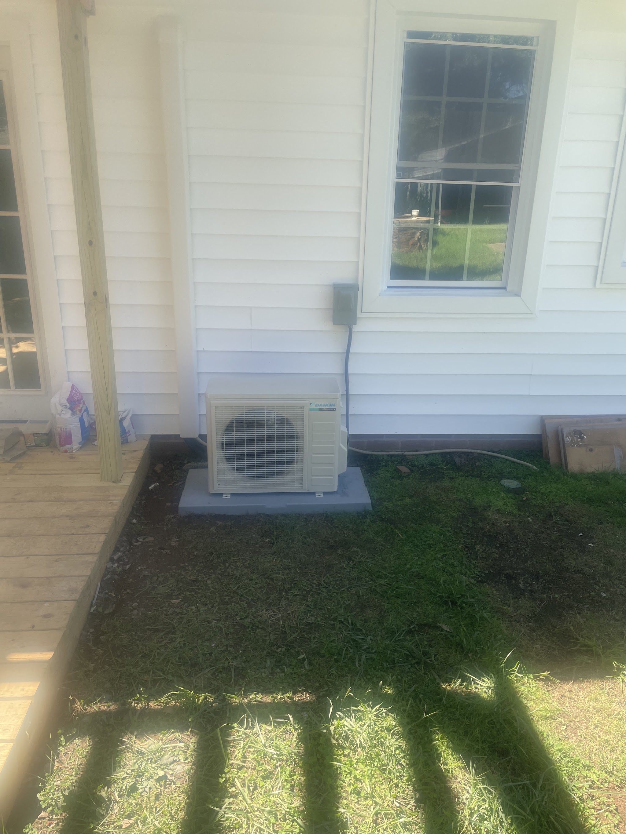 Ductless mini-split outdoor unit beside a porch